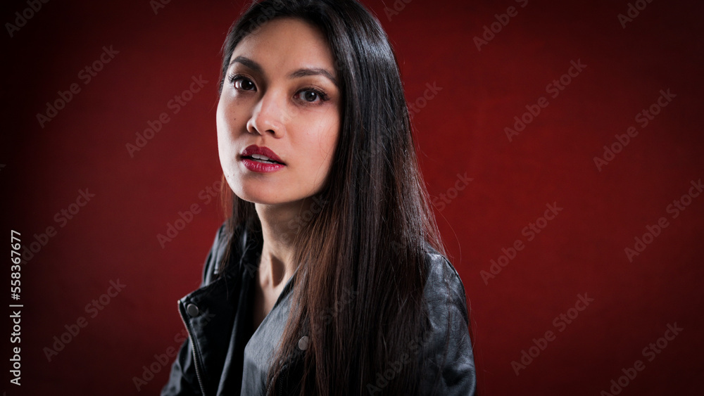 Young pretty woman in black leather jacket posing for the camera - studio photography Young pretty woman in black leather jacket posing for the camera - studio photography
