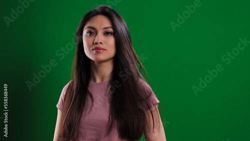 Young confident woman against a green background - studio photography © 4kclips