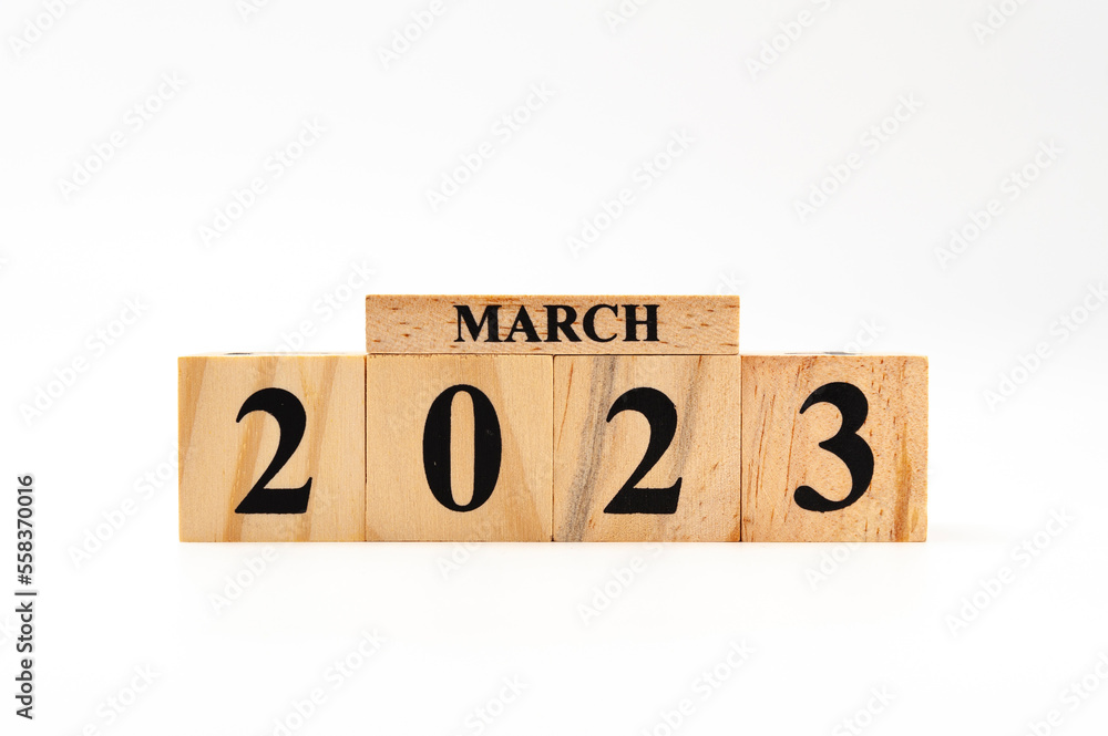 March 2023 written on wooden blocks isolated on white background with copy space