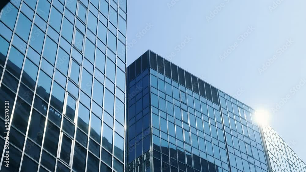 Abstract modern business architecture. Walls made of glass and steel with reflections of buildings and blue sky. Abstract modern business architecture. Walls made of glass and steel with reflections of buildings and blue sky.