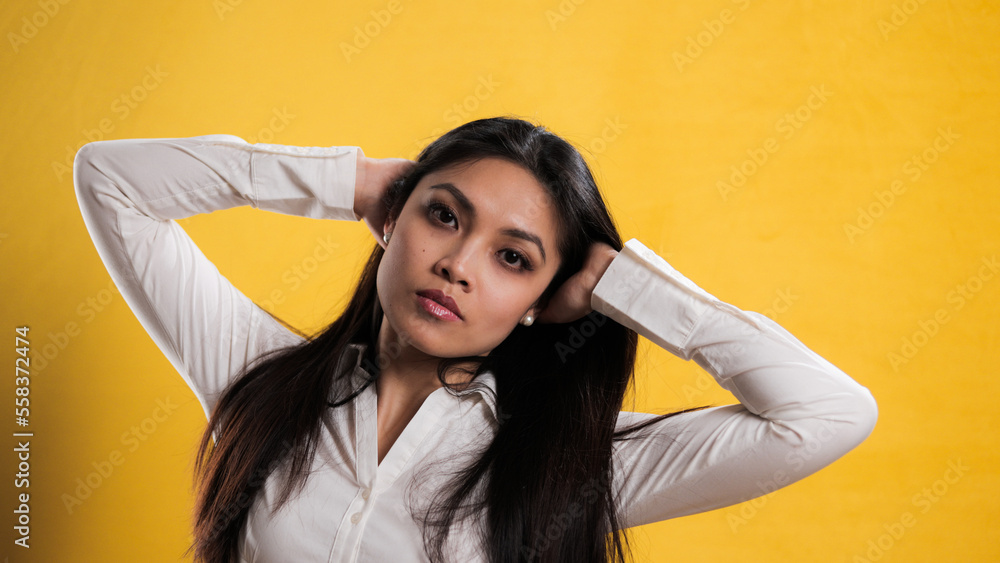 Naklejka premium Young pretty woman with Asian appearance posing for the camera - studio photography