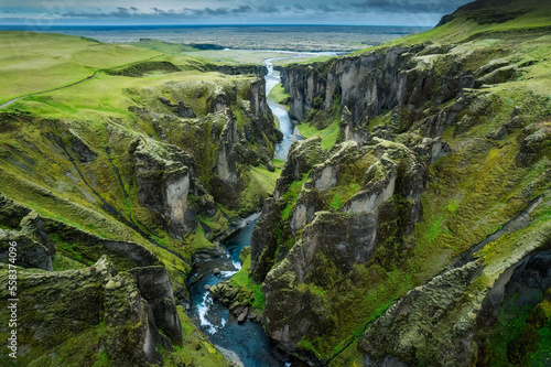 Stunning view of Fjadrargljufur canyon naturally eroded with Fjadra flowing through ravine in summer at Iceland photo