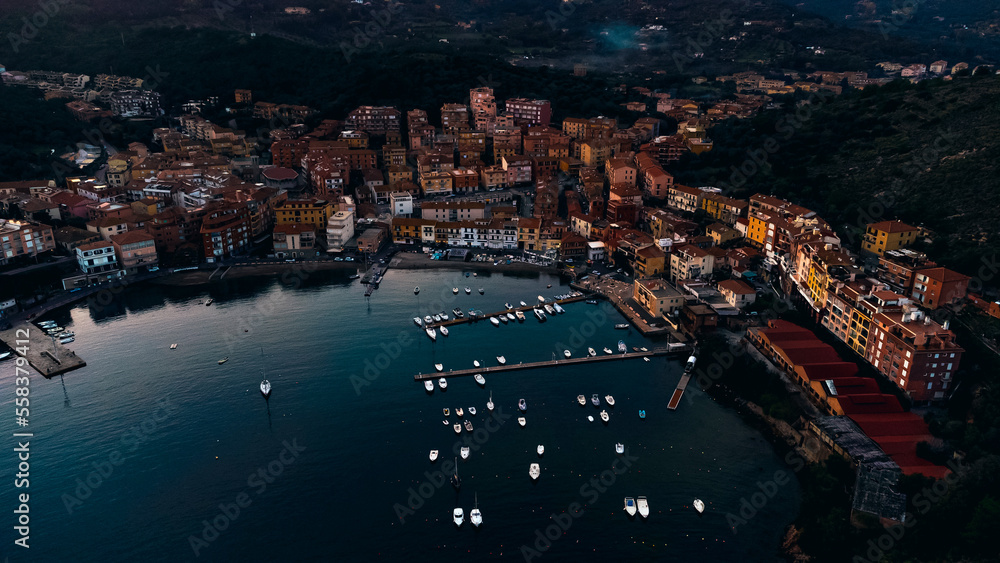 Top view of the small town of Porto Ercole, Tuscany Italy at sunset. Harbor with boats, fishing boats, emerald coast and city