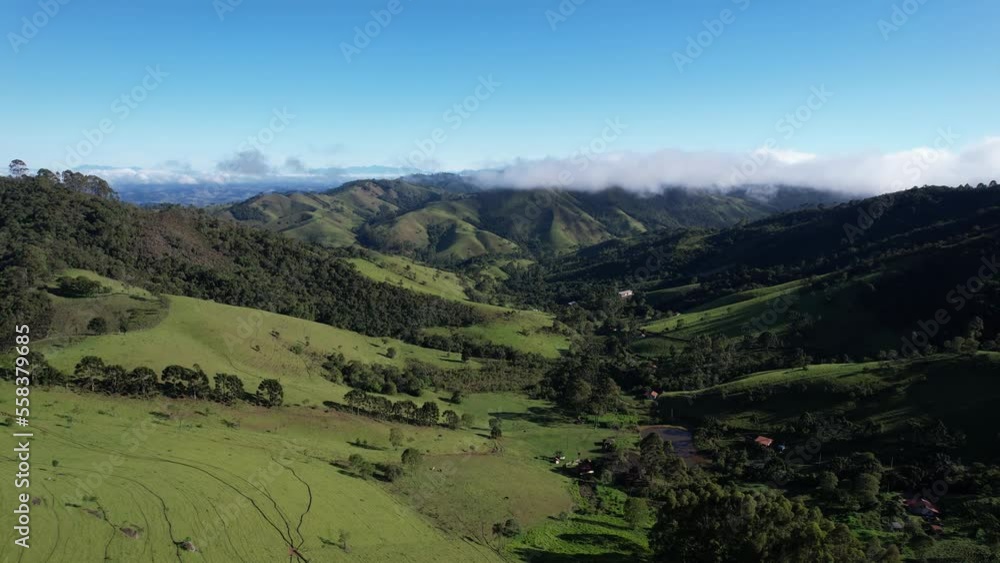 Aerial view of mountains in a rural area in the interior of São Paulo. Trees, vegetation, small houses and blue sky. Aerial view of mountains in a rural area in the interior of São Paulo. Trees, vegetation, small houses and blue sky.
