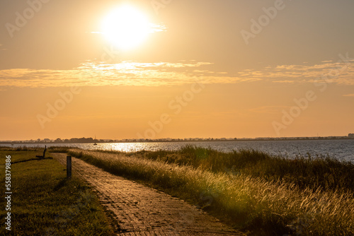 golden hour evening panorama with cobblestone path at coast line at marken island