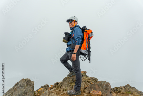man hiker with backpack in front of a mountain