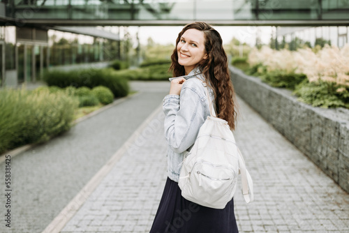 Happy pretty young brunette woman with backpack
