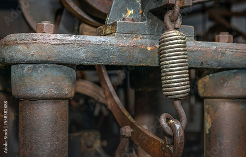 Obraz na płótnie Close-up of a shiny steel spring as part of an unknown heavy machine that has been disused for a long time. w salonie