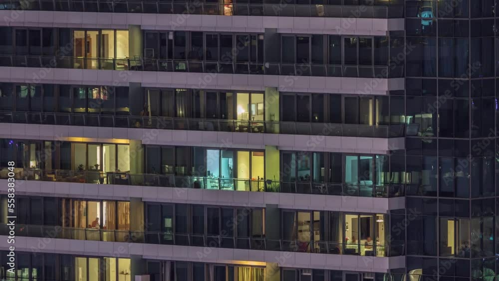 Windows lights in modern residential buildings timelapse at night. Multi-level skyscrapers with illuminated rooms inside Windows lights in modern residential buildings timelapse at night. Multi-level skyscrapers with illuminated rooms inside