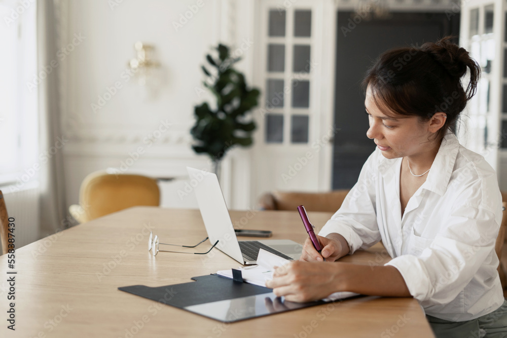 Employee workplace in a modern office. A freelancer woman is doing work on a startup, using a laptop. Employee workplace in a modern office. A freelancer woman is doing work on a startup, using a laptop.