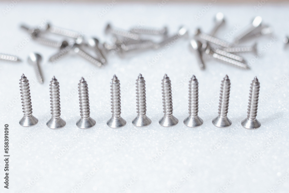 Tapping screws made of steel on table background, metal screw, iron screw, chrome screw, screws as a background, wood screw, concept industry. copy space for text. Tapping screws made of steel on table background, metal screw, iron screw, chrome screw, screws as a background, wood screw, concept industry. copy space for text.