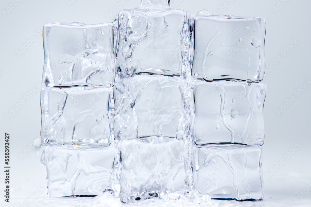 Water flows down over ice cubes on a white background Water flows down over ice cubes on a white background