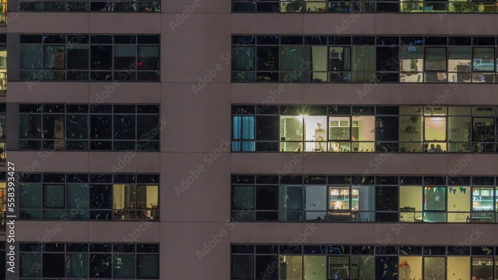 Windows lights in modern apartment buildings timelapse at night. Multi-level skyscrapers with illuminated rooms inside Windows lights in modern apartment buildings timelapse at night. Multi-level skyscrapers with illuminated rooms inside
