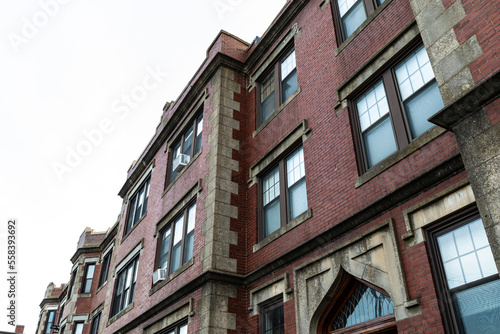 Beautifully featured architectural details on a classic old urban apartment building with corner quoins, leaded windows, and elaborate mouldings, horizontal aspect