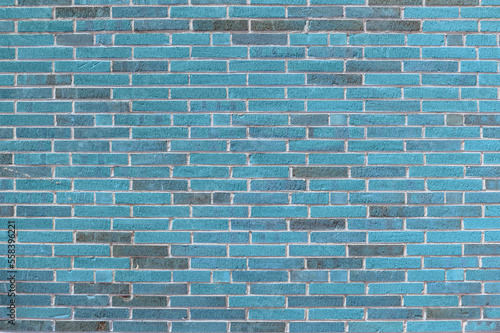 Background of blue brick with finely textured combed surface, long brick in running bond pattern, creative copy space, horizontal aspect