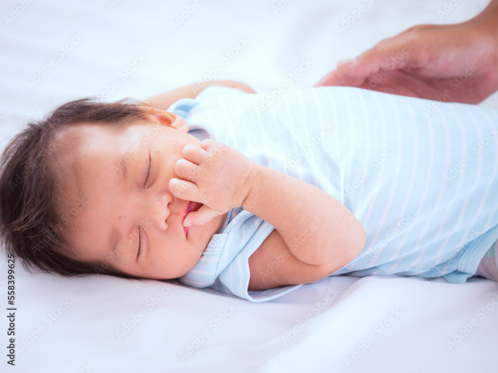Portrait of three weeks Australian Asian newborn baby or infant lying on the white bed and close her eyes.. Portrait of three weeks Australian Asian newborn baby or infant lying on the white bed and close her eyes..