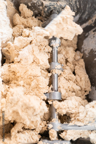 A kneading machine is mixing the corn dough to prepare tortillas in Mexico. Close up photo