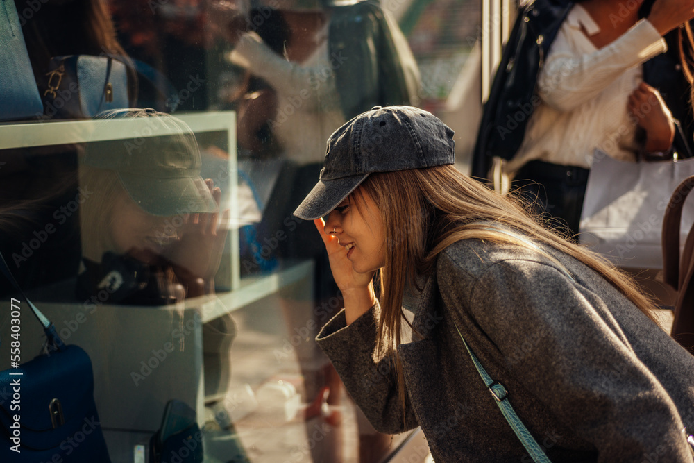 Blonde girl looking closely to the shop window Blonde girl looking closely to the shop window
