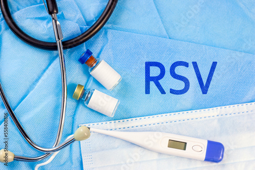 RSV letters with different medical equipment aside on light blue background. Respiratory Syncytial Virus disease concept. photo