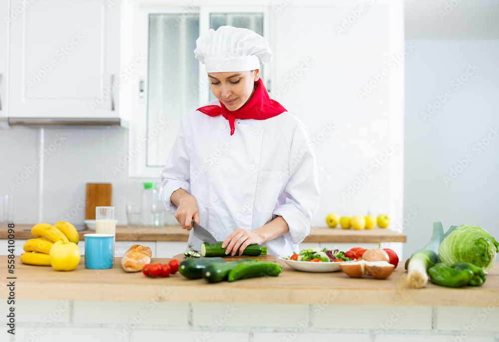 Proffesional woman cook in white uniform chopping vegetables Proffesional woman cook in white uniform chopping vegetables