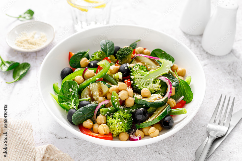 Chickpea and spinach vegan vegetable salad with broccoli, sweet pepper, olives and grilled zucchini. Mediterranean diet, healthy food Chickpea and spinach vegan vegetable salad with broccoli, sweet pepper, olives and grilled zucchini. Mediterranean diet, healthy food