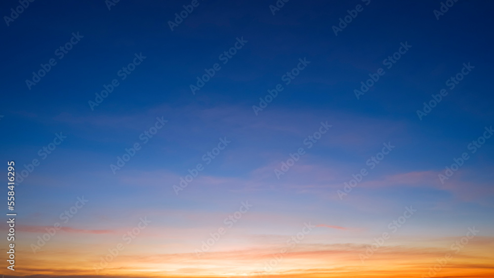 Dusk sky background with beautiful sunlight and sunset cloud after sundown on blue Twilight sky, idyllic peaceful nature background