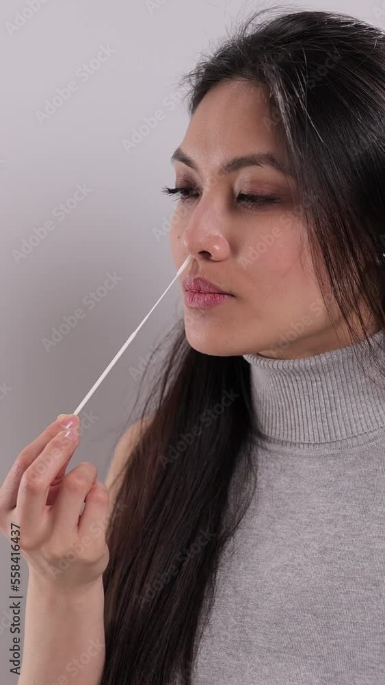 Young woman performs a Covid-19 antigen self-test - studio shooting Young woman performs a Covid-19 antigen self-test - studio shooting