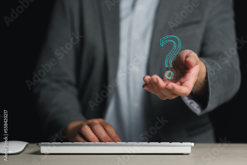 Businessman on blurred background holding hand drawn question mark
