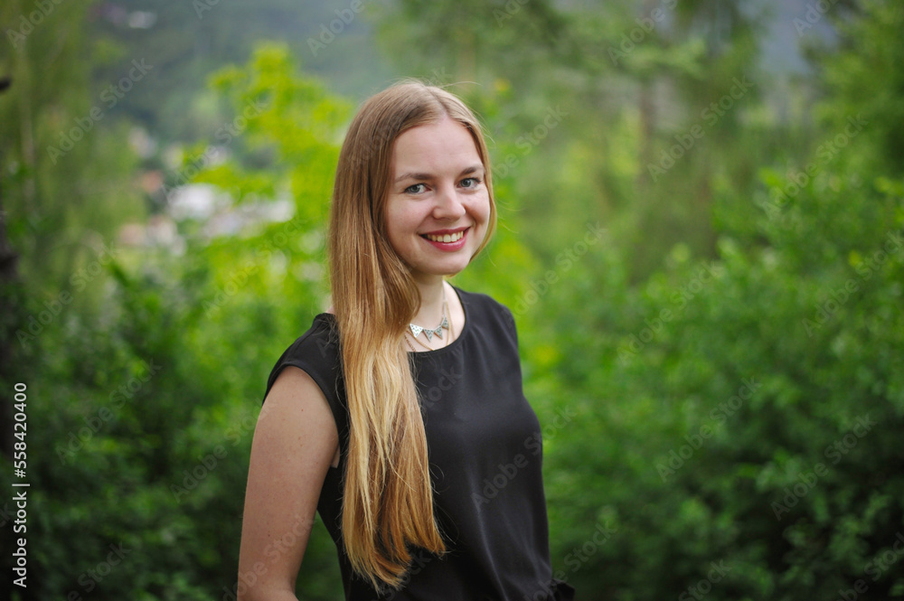 charming charming cute smiling girl with an open, honest face against a forest in a soft light charming charming cute smiling girl with an open, honest face against a forest in a soft light