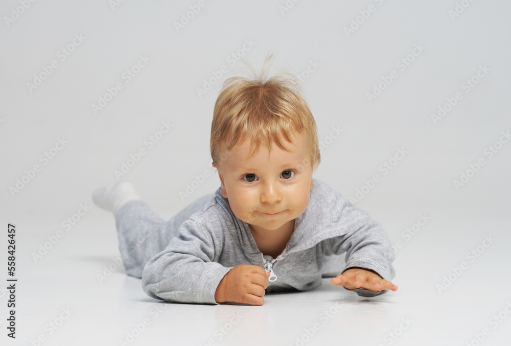 Little, happy and smiling cute baby in the studio. Portrait of a one year old baby. The concept of happiness. Little, happy and smiling cute baby in the studio. Portrait of a one year old baby. The concept of happiness.