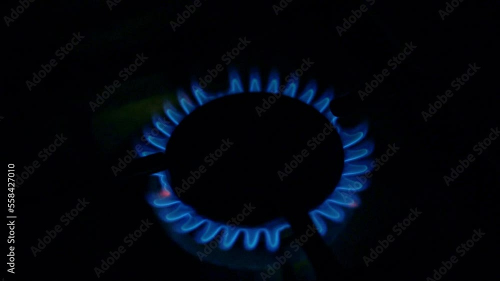 Flame Gas Fire Kitchen Burner on Stove in Darkness Close-up. Chef Turns on the Gas Burner. Turning on the Burner on the Stove in the Dark. Switching on the Gas Stove Closeup Macro in the Dark. Flame Gas Fire Kitchen Burner on Stove in Darkness Close-up. Chef Turns on the Gas Burner. Turning on the Burner on the Stove in the Dark. Switching on the Gas Stove Closeup Macro in the Dark.