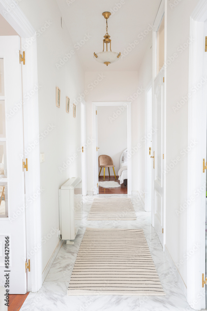 White painted hallway with rugs and white lacquered doors