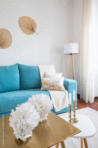 Fototapeta Naklejka Na Ścianę i Meble -  Living room with green sofa, white walls, wooden floor and cushions with flowers