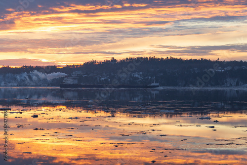 Empty cargo boat moving along the St. Lawrence River during a pink and orange winter sunrise  Cap-Rouge area  Quebec City  Quebec  Canada