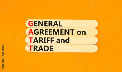 GATT symbol. Concept words GATT general agreement on tariff and trade on wooden stick on beautiful orange background. Business GATT general agreement on tariff and trade concept. Copy space.