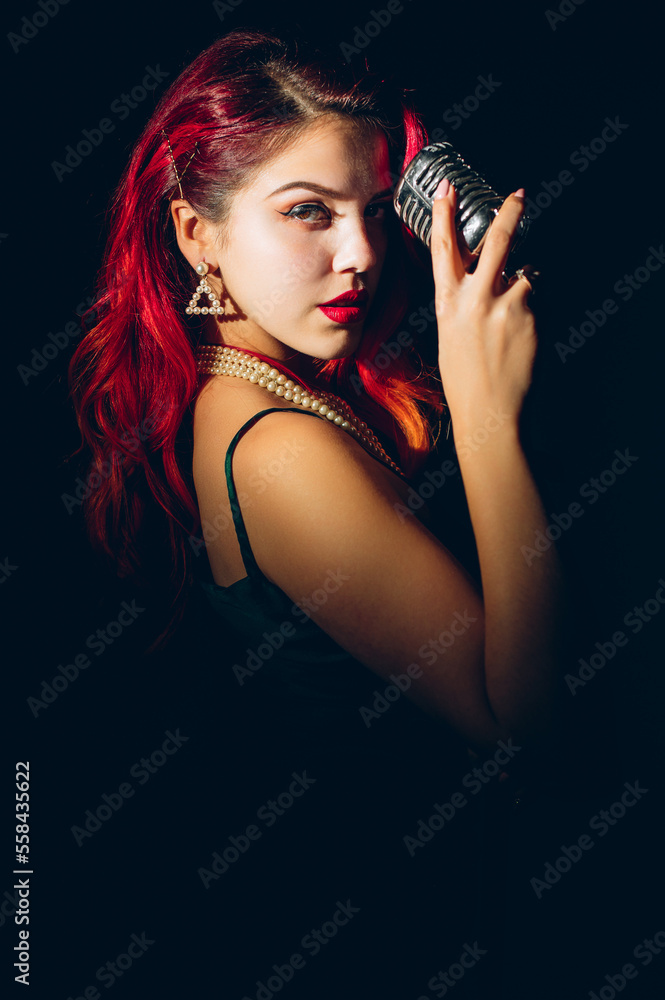 Gorgeous red haired woman singing with retro microphone on the stage Gorgeous red haired woman singing with retro microphone on the stage