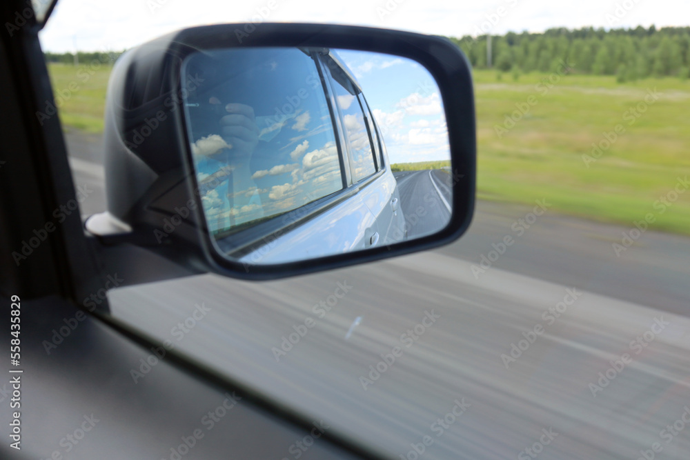 View from the car on the road through yellow fields on a sunny day