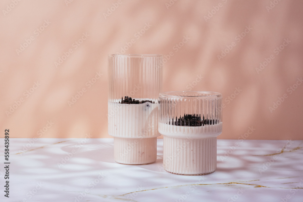 yogurt with berries in a glass on a light pink background yogurt with berries in a glass on a light pink background