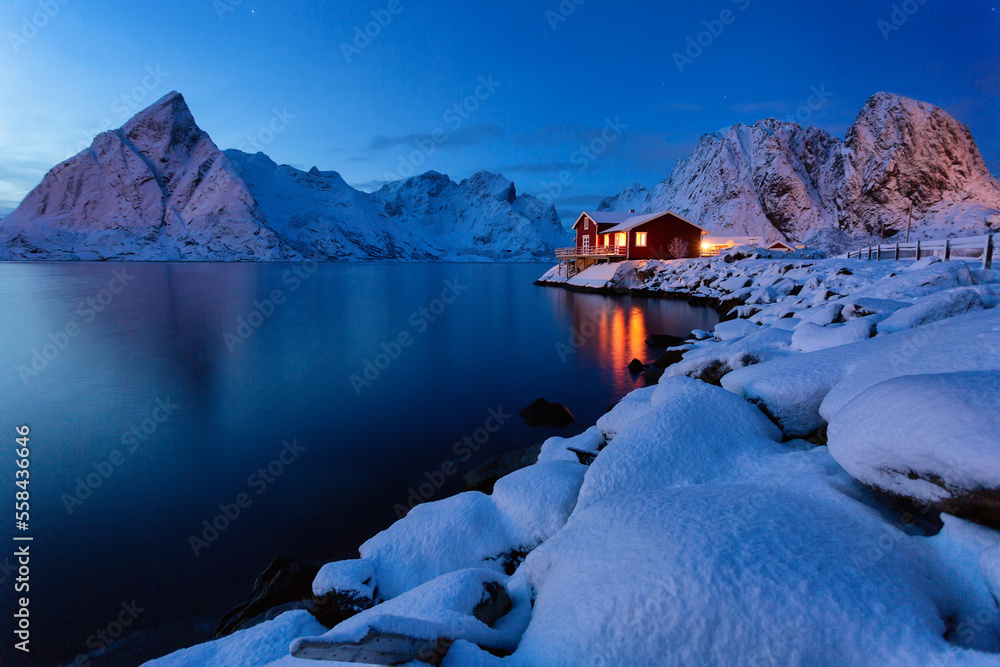 Night landscape traditional Scandinavian red house called rorbue standing alone on the fjord