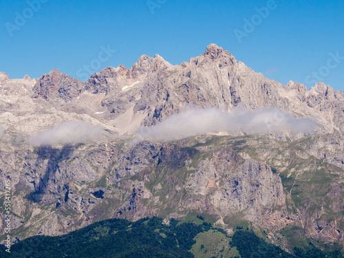 Altas montañas rocosas con algunas manchas de niebla y cielo azul. photo