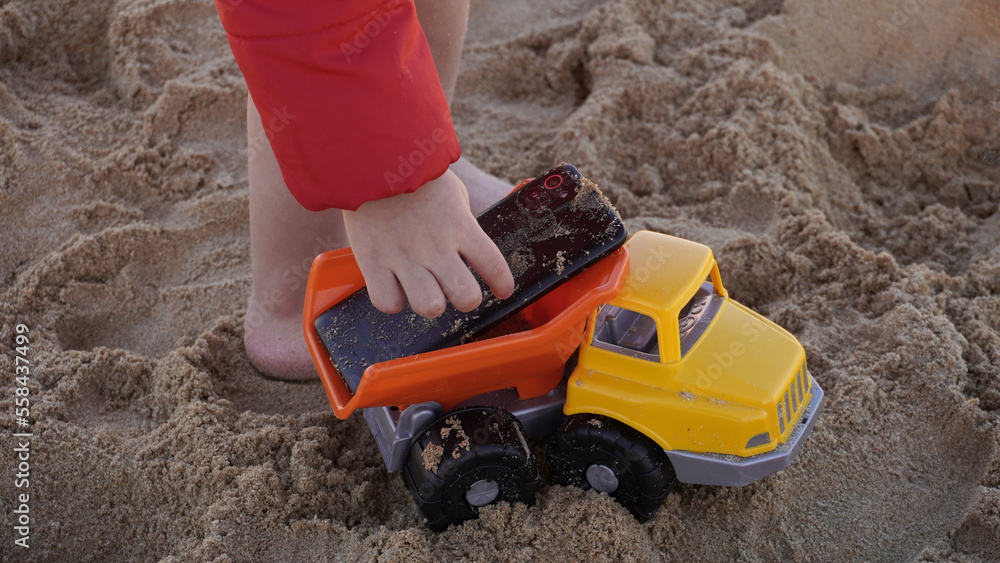 child placing a phone ensima of a toy car child placing a phone ensima of a toy car