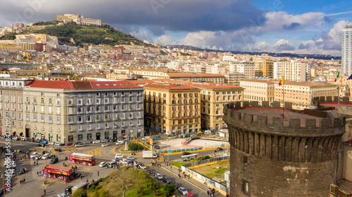 Aerial view of a tower of Maschio Angioino, a medieval castle located in Municipio square in the historic center of Naples, Italy. In the background Castel Sant' Elmo and Vomero hill.
