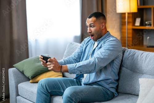 Man with smartphone being surprised as playing games