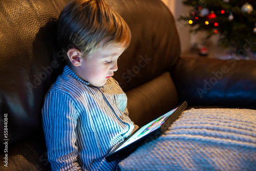 jeune enfant utilisant une tablette ordinateur à la maison photo