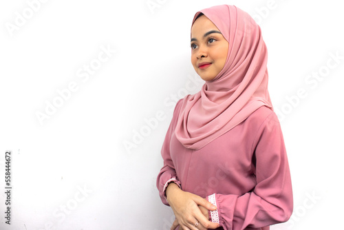 Beautiful smiling Asian woman in pink hijab crossed arms and looking at copy space isolated on white background. People islam religious concept