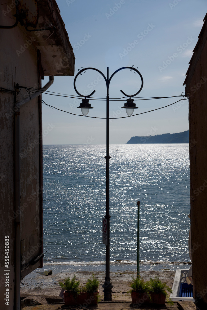 lamppost in an alley that leads to the sea