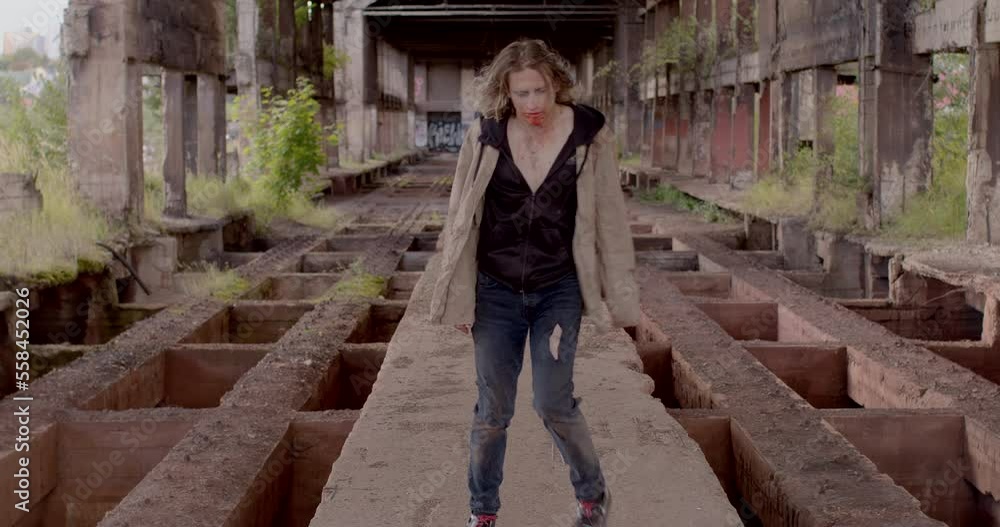 Zombie movement in an abandoned building, bloodied face. Against the backdrop of an empty building perspective. He goes down. Zombie movement in an abandoned building, bloodied face. Against the backdrop of an empty building perspective. He goes down.