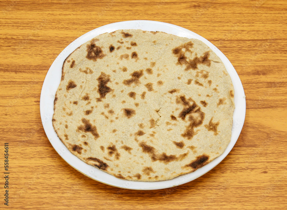 Simple tandoori roti served in plate isolated on table top view of indian and pakistani spicy food Simple tandoori roti served in plate isolated on table top view of indian and pakistani spicy food