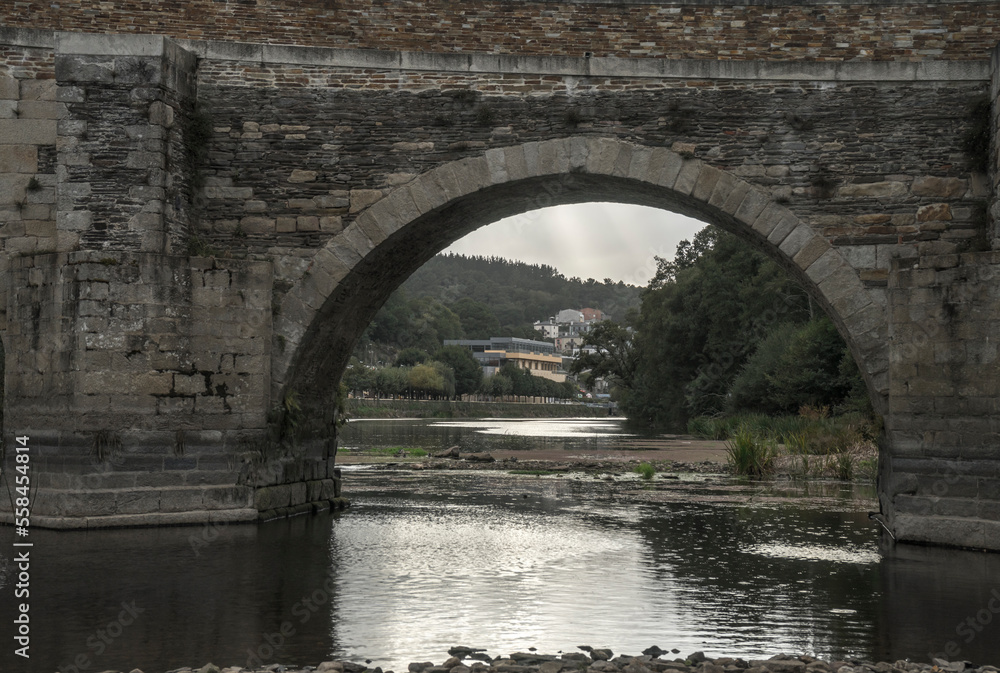 Beautiful Roman bridge in the town of Lugo on a cloudy day in December, Galicia, Spain.