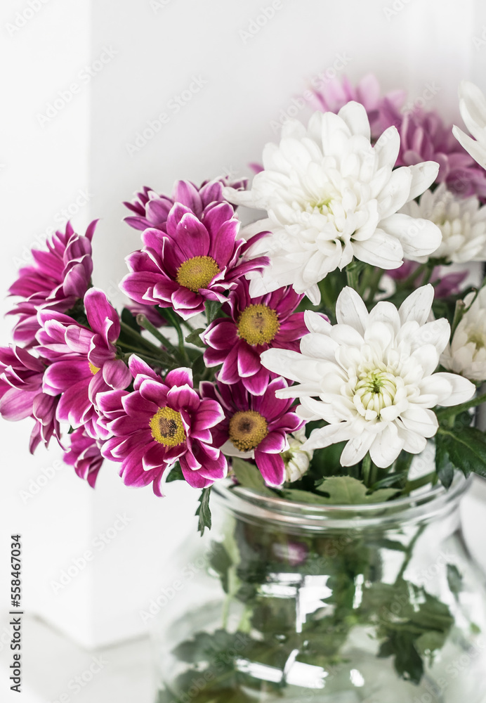 Vase with multi-colored chrysanthemums on the windowsill closeup. Vase with multi-colored chrysanthemums on the windowsill closeup.